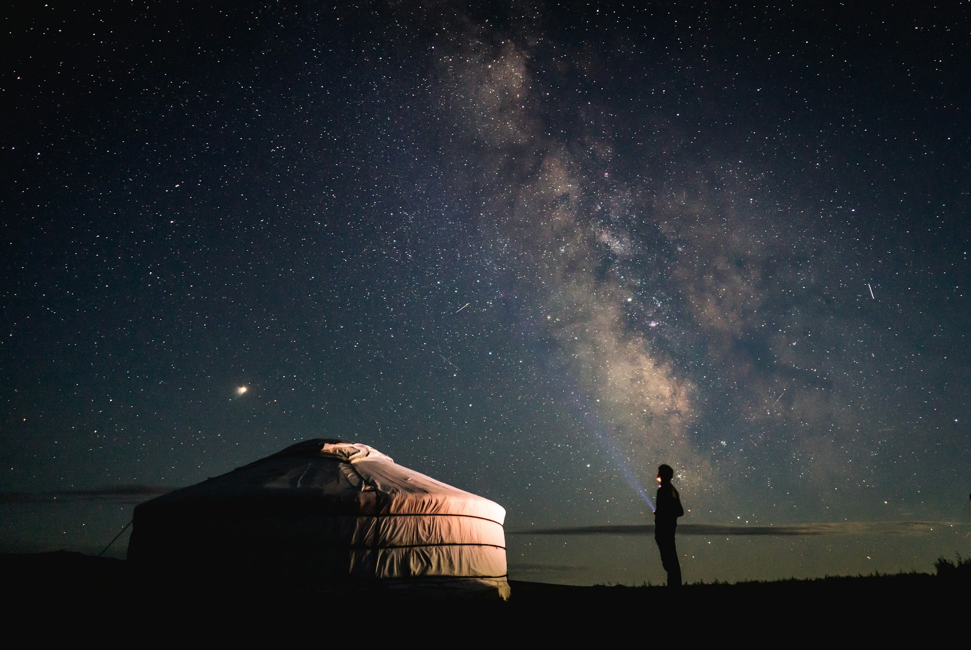 Image of camping outdoors in a yurt to convey benefits of digital nomad travel planning star gazing - Odyssey App